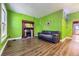 Cozy living room with hardwood floors, a decorative fireplace, and bright green walls at 3064 S Cherokee St, Englewood, CO 80110