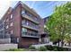 Multi-story brick building with multiple balconies in an urban area under a clear blue sky at 830 N Sherman St # 205, Denver, CO 80203