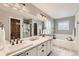 Bright bathroom with double sinks, a walk-in shower, a soaking tub, and modern fixtures at 1157 Mircos St, Erie, CO 80516