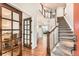 Elegant foyer showcasing hardwood floors, an open staircase, and glass French doors to the left at 1157 Mircos St, Erie, CO 80516