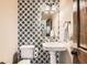 Stylish powder room featuring designer wallpaper, a pedestal sink, and modern lighting at 1157 Mircos St, Erie, CO 80516