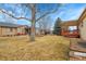 Spacious backyard with a covered deck, mature trees, and well-maintained lawn at 9693 W Euclid Dr, Littleton, CO 80123