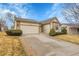 Charming exterior with tan siding, stone accents, well maintained lawn, and a two-car garage at 9693 W Euclid Dr, Littleton, CO 80123