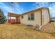 Back exterior of house showing covered deck, patio, and lawn at 9693 W Euclid Dr, Littleton, CO 80123