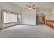 Open living room featuring ceiling fan, large windows, and staircase for a bright, welcoming space at 9693 W Euclid Dr, Littleton, CO 80123