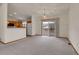 Open living area with connecting kitchen and sliding door to deck, with neutral walls and flooring at 9693 W Euclid Dr, Littleton, CO 80123