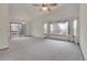 Spacious living room with a ceiling fan, large windows, and a sliding door leading to the deck at 9693 W Euclid Dr, Littleton, CO 80123