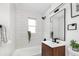 Modern bathroom featuring subway tile, dark fixtures, and a stylish vanity with a wood grain cabinet at 2293 S Sherman St, Denver, CO 80210