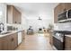 Modern kitchen with stainless appliances, a view into the living room, and light wood flooring at 2293 S Sherman St, Denver, CO 80210