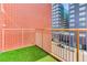 View of balcony with artificial turf and railings overlooking street with parked cars and modern buildings at 3100 Huron St # 4N, Denver, CO 80202