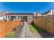 Backyard with brick house, modern fence and paver stone walkway at 3329 N High St, Denver, CO 80205