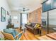 Stylish living room with open layout, hardwood floors, and an exposed brick wall at 3329 N High St, Denver, CO 80205