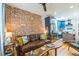 Open-concept living space with modern kitchen, exposed brick, and stylish furniture at 3329 N High St, Denver, CO 80205