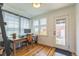 Bright office space with hardwood floors, a computer desk, and a door leading to the backyard at 3329 N High St, Denver, CO 80205