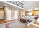 Bright living room featuring an open floor plan, wooden floors, neutral-toned walls, and a view into the kitchen at 6515 S Killarney Ct, Aurora, CO 80016