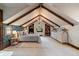 Cozy bedroom under vaulted ceiling with exposed beams and wallpapered accent wall at 5085 Knobcone Dr, Castle Rock, CO 80108