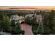 A stunning home with an expansive driveway surrounded by lush landscaping and mature trees at 5085 Knobcone Dr, Castle Rock, CO 80108