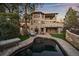Back exterior view of home with patio, pool, and stone accents at 5085 Knobcone Dr, Castle Rock, CO 80108