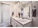 Bathroom with double sinks, modern lighting, large mirror, and wood look flooring at 4746 River Highlands Loop, Elizabeth, CO 80107