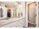Bathroom with double sink vanity, decorative mirror, and plenty of lighting at 4746 River Highlands Loop, Elizabeth, CO 80107