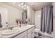 Bathroom featuring double sinks, a shower/tub combo, and a gray shower curtain at 4746 River Highlands Loop, Elizabeth, CO 80107
