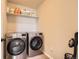 Laundry room with gray tile floors and stainless steel washer and dryer at 4746 River Highlands Loop, Elizabeth, CO 80107