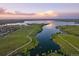 Stunning aerial view showcasing the community's serene lake and surrounding walking trails at sunset at 27608 E Ottawa Ave, Aurora, CO 80016