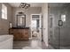 Modern bathroom featuring a wood vanity, soaking tub, glass-enclosed shower and stylish lighting at 27608 E Ottawa Ave, Aurora, CO 80016