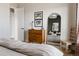 Bright bedroom featuring a wooden dresser, a large mirror, and stylish decor elements at 27608 E Ottawa Ave, Aurora, CO 80016