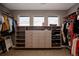 Spacious walk-in closet with custom shelving and drawers for organized storage and three sunny windows at 27608 E Ottawa Ave, Aurora, CO 80016
