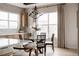 Bright dining room with modern chandelier, light wood floors, and decorative wallpaper at 27608 E Ottawa Ave, Aurora, CO 80016