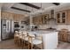 Bright kitchen features an island with seating, wood cabinets, patterned backsplash, stainless steel appliances, and modern lighting at 27608 E Ottawa Ave, Aurora, CO 80016