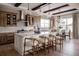 Bright kitchen features an island with seating, patterned backsplash, wood cabinets, stainless steel appliances, and modern lighting at 27608 E Ottawa Ave, Aurora, CO 80016