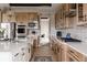 Spacious kitchen features a long island, wood cabinets, patterned backsplash, stainless steel appliances, and hardwood floors at 27608 E Ottawa Ave, Aurora, CO 80016