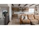 Open-concept kitchen features an island with seating, wood cabinets, and stainless steel appliances, flowing into the living space at 27608 E Ottawa Ave, Aurora, CO 80016