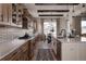 Spacious kitchen features a long island, wood cabinets, patterned backsplash, stainless steel appliances, and hardwood floors at 27608 E Ottawa Ave, Aurora, CO 80016
