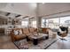 Open-concept living space flows from the kitchen and features hardwood floors, and a brown leather sectional sofa at 27608 E Ottawa Ave, Aurora, CO 80016