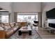 Spacious living room with large windows, a brown sectional sofa, a patterned rug, and a modern accent chair at 27608 E Ottawa Ave, Aurora, CO 80016