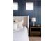 Cozy primary bedroom detail featuring accent wall, side table, and luxury linens at 27608 E Ottawa Ave, Aurora, CO 80016
