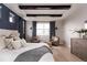 Bright primary bedroom featuring exposed beams, sitting area, and stylish decor at 27608 E Ottawa Ave, Aurora, CO 80016