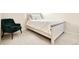 Bright bedroom with a rustic wood bed frame, plush pillows, and a green accent chair at 320 Marshall Mews, Superior, CO 80027