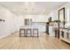 Bright, modern kitchen features stainless appliances, white cabinets, light countertops, and an island with stool seating at 320 Marshall Mews, Superior, CO 80027
