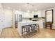 Bright, modern kitchen features stainless appliances, white cabinets, light countertops, and an island with stool seating at 320 Marshall Mews, Superior, CO 80027
