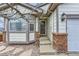 Home's front door featuring stone detailing, front storm door, and a bay window at 815 Concho Ct, Castle Rock, CO 80104