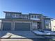 Two-story modern home with gray siding, three-car garage, and stone accents at 4926 Coal Bank Dr, Castle Rock, CO 80104