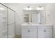 This bathroom has a double vanity, a shower with glass doors, and white cabinets at 842 N Deer Park St, Watkins, CO 80137