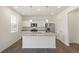 Contemporary kitchen featuring an island with granite countertop, stainless steel appliances and white cabinetry at 842 N Deer Park St, Watkins, CO 80137