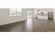 Bright, open-concept living room featuring wood floors and a modern kitchen with stainless steel appliances at 842 N Deer Park St, Watkins, CO 80137