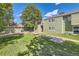 View of the green townhome from the lawn, showcasing its inviting curb appeal at 940 S Peoria St, Aurora, CO 80012