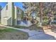 Exterior view of a green townhome with a fenced patio and a large tree in the yard at 940 S Peoria St, Aurora, CO 80012